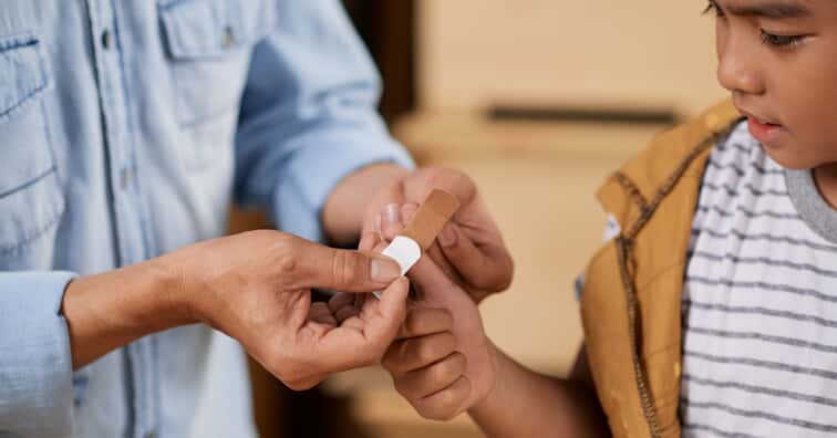 Kid getting a bandaid put on for them