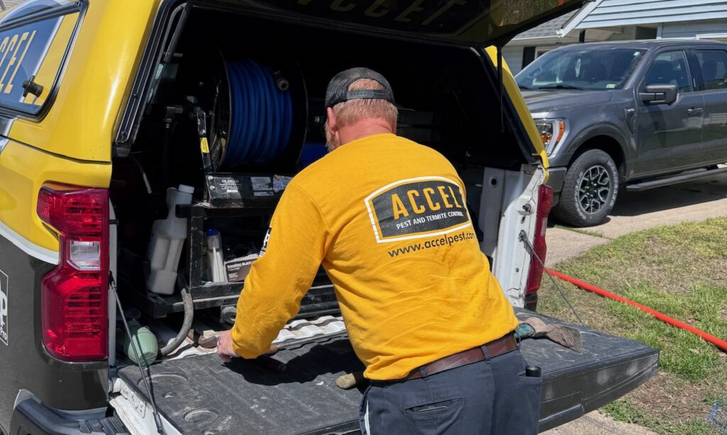 A pest control professional from Accel gathers tools to conduct a home inspection.
